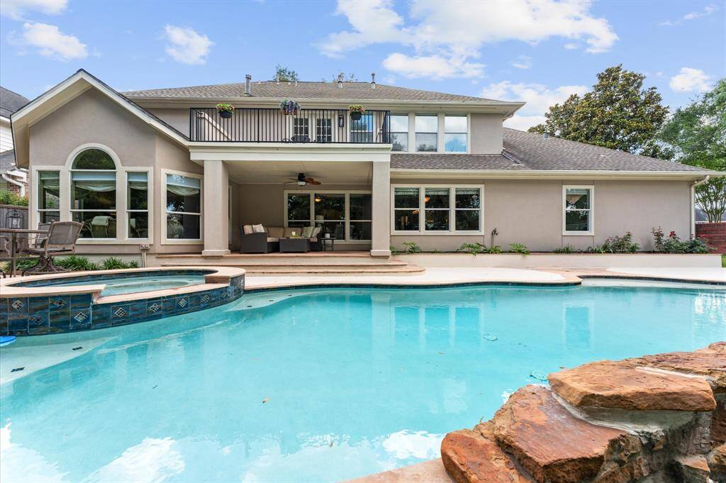This view shows the covered patio and upstairs balcony.