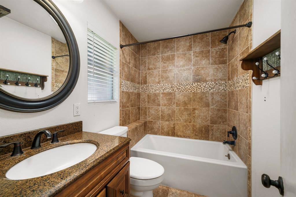 Luxurious en-suite bath features granite, large tub shower with beautiful tile surround.