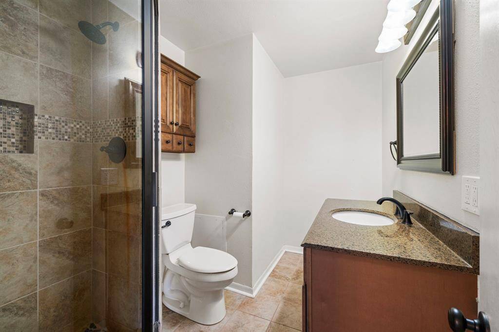 The secondary bath is equally impressive, featuring granite countertops and an oversized walk in shower with floor to ceiling tile surround.