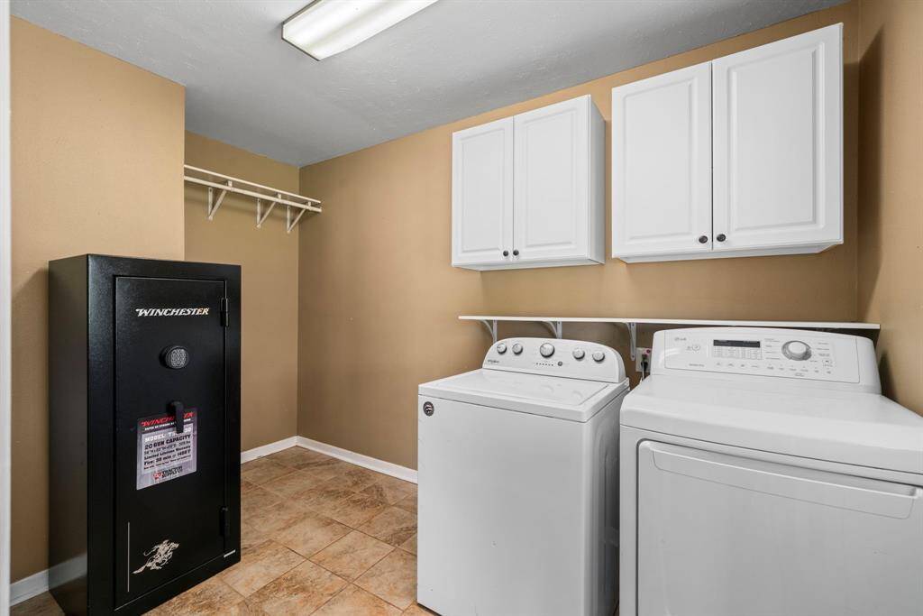 Spacious laundry/mud room with shelving and custom cabinets. Ample room for an extra refrigerator or freezer.
