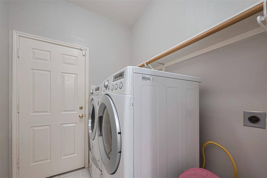 Laundry room conveniently located at the garage entryway with hanging and shelves area.