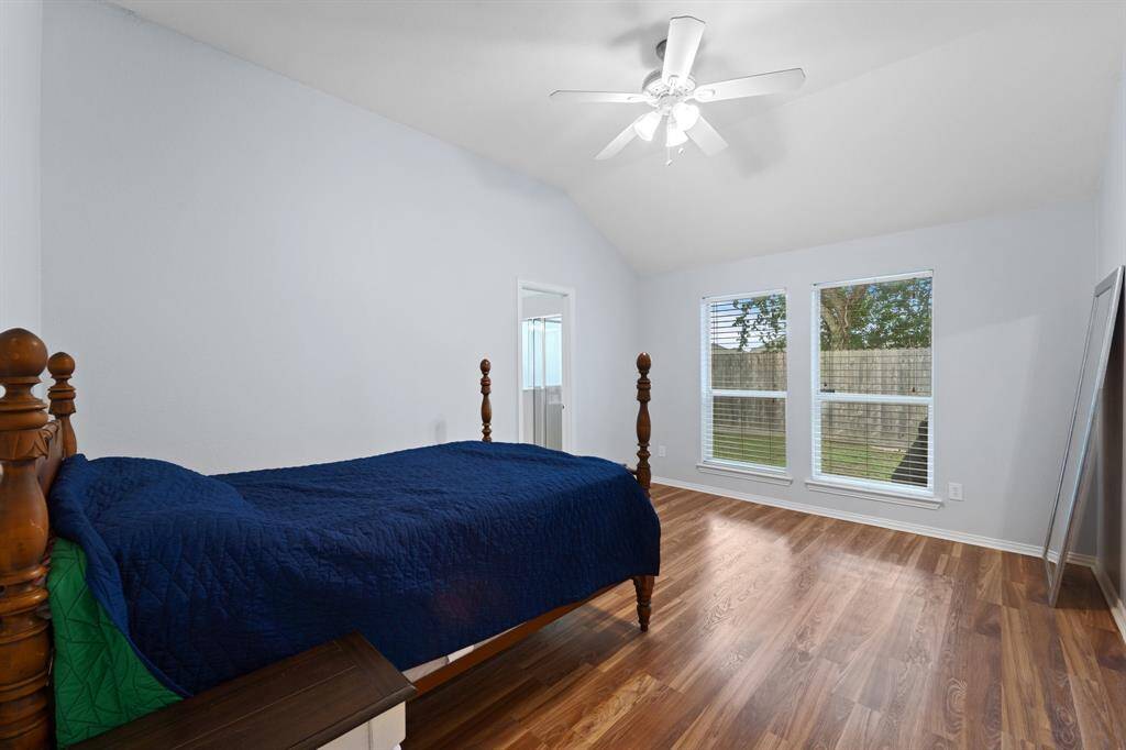 Primary bedroom off the back of the home with access from the family room has two large windows allowing in natural light.