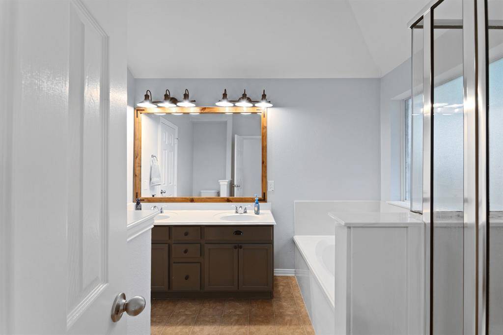 Primary bathroom with separate tub and shower and dual sinks.