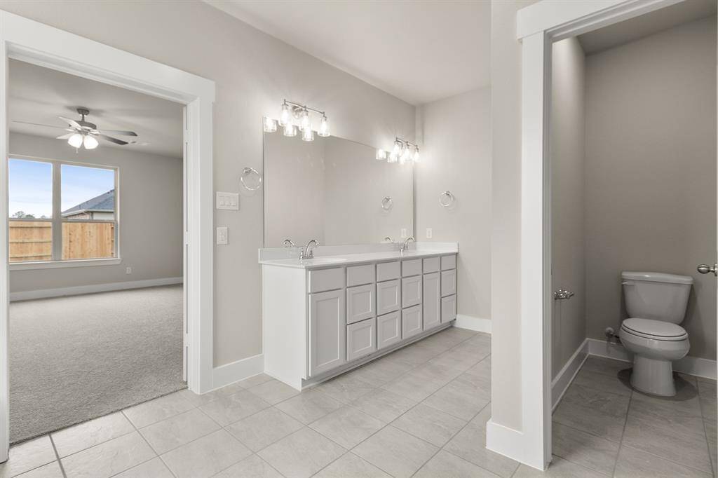 The soft glow of natural light filters through large windows, highlighting the elegant finishes – polished countertops and luxurious tile work that catches your eye and invites you to linger.