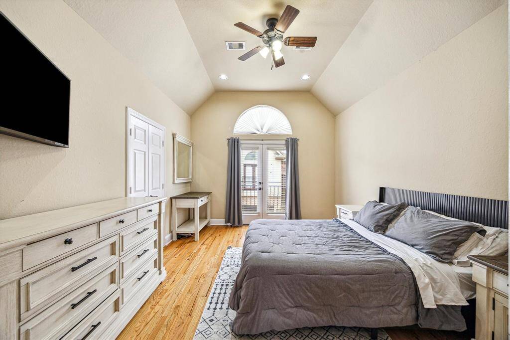 Primary bedroom with high ceilings and Juliet balcony. Door to left opens to ensuite bathroom and large walk in closet.