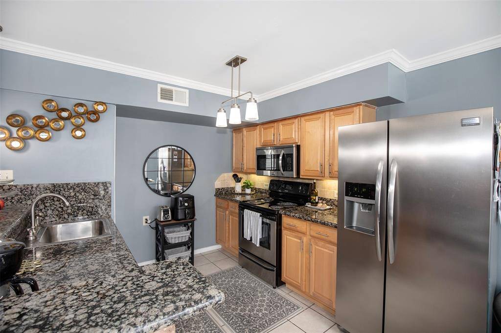 Rich cabinetry adds warmth to the space, while the open layout ensures easy flow into the adjacent living and dining areas.