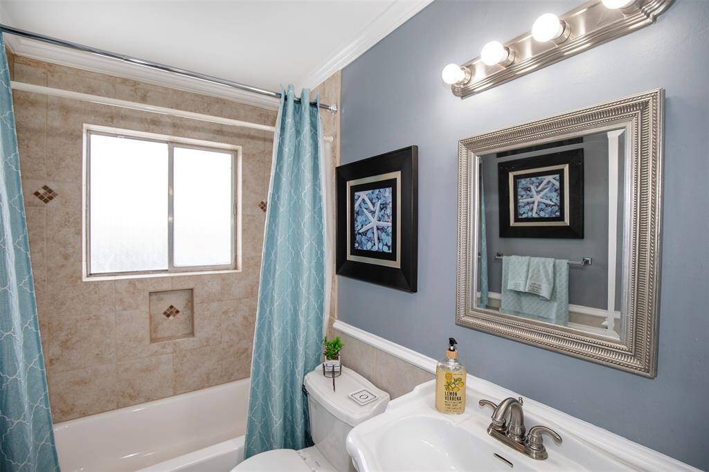 The guest bathroom has beautiful tile around the tub.