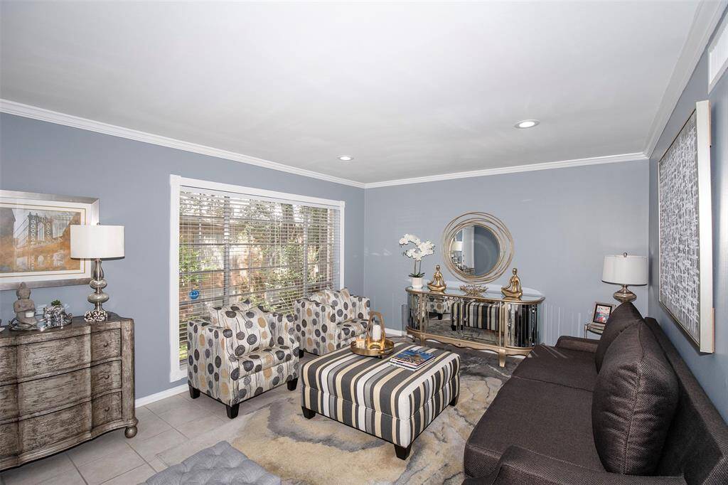 The formal living space has a large window that allows the natural light to flow through the room.
