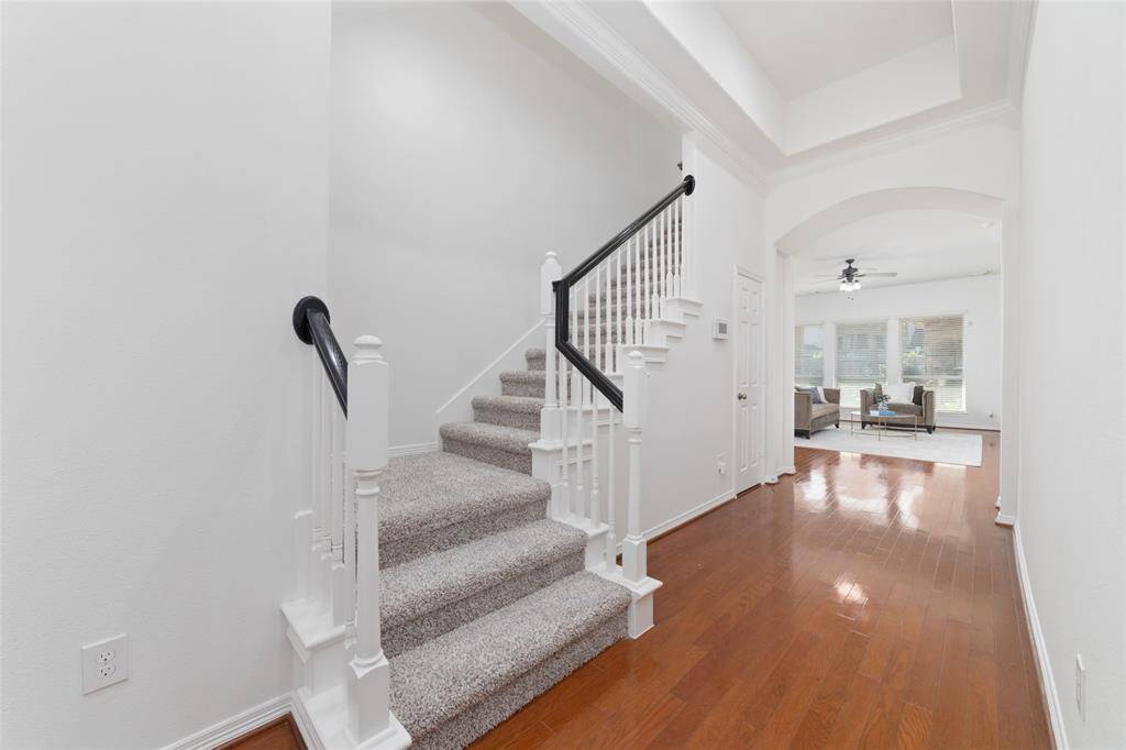 As you pass the dining room and study, you are lead to the hallway leading to a well-lit living area with large windows and a hallway to the right leads to two secondary bedrooms, full bathroom, and desk space.