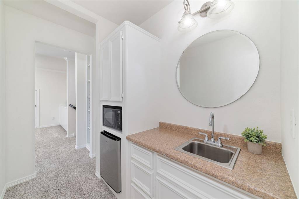 Upstairs is a wet bar with sink, microwave, and small fridge for movie nights.