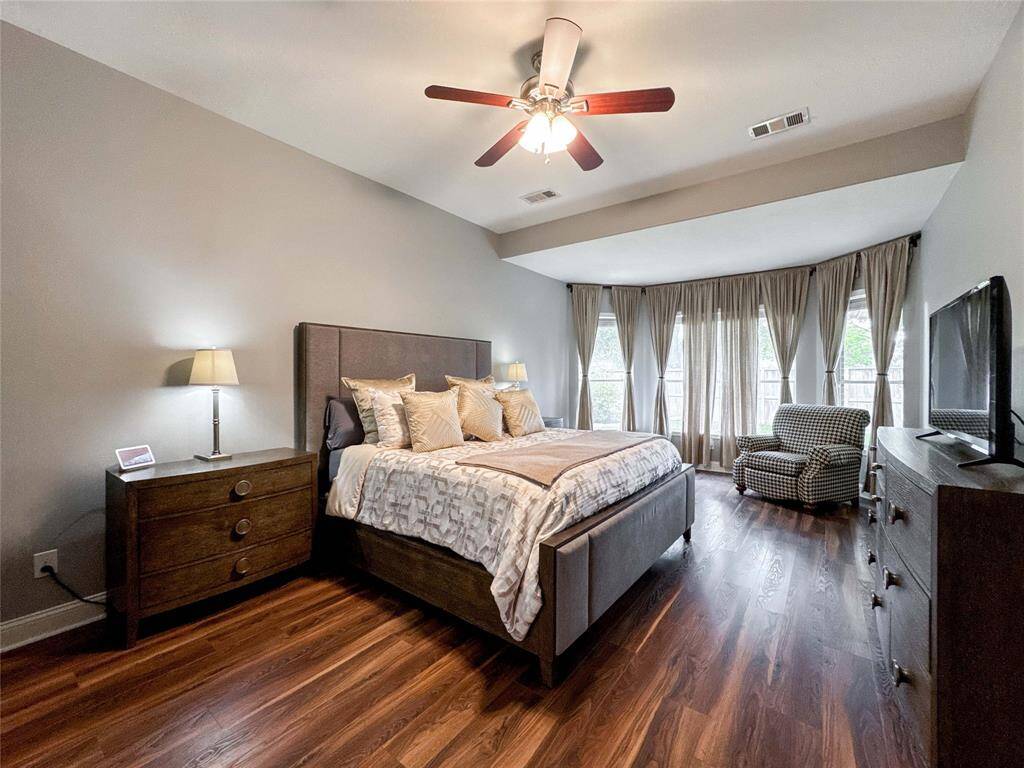 Alternate view of the spacious bedroom with luxury vinyl floors, and gorgeous natural light from multiple windows.