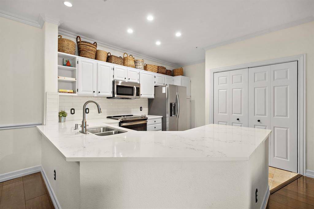 The kitchen's vast island doubles as a breakfast bar for serving drinks and meals. Find multiple built-in drawers and cabinetry, thoughtfully designed for easy storage of pots, pans, and kitchen essentials.