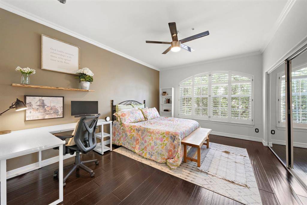 Wake up to bright and refreshing mornings in the spacious secondary bedroom with an accent wall and huge windows w/ plantation shutters.