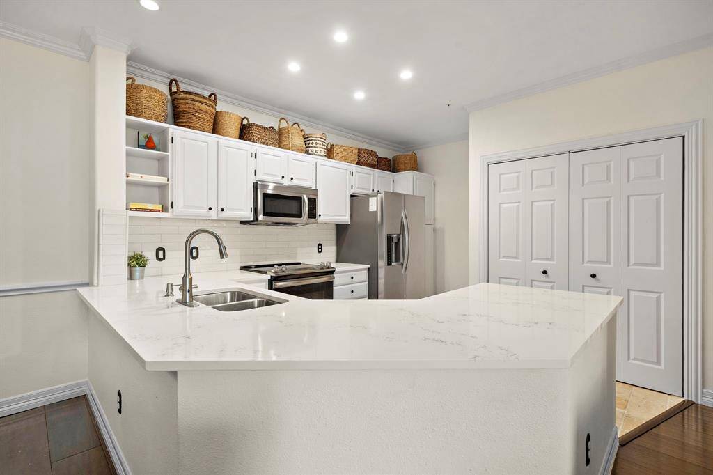 Showcasing the ideal blend of form and function, the kitchen is a chef’s dream with vast quartz countertops, stainless steel appliances, a wine fridge, and a breakfast bar. Find plenty of storage space courtesy of the numerous cabinets and open shelving for added convenience.