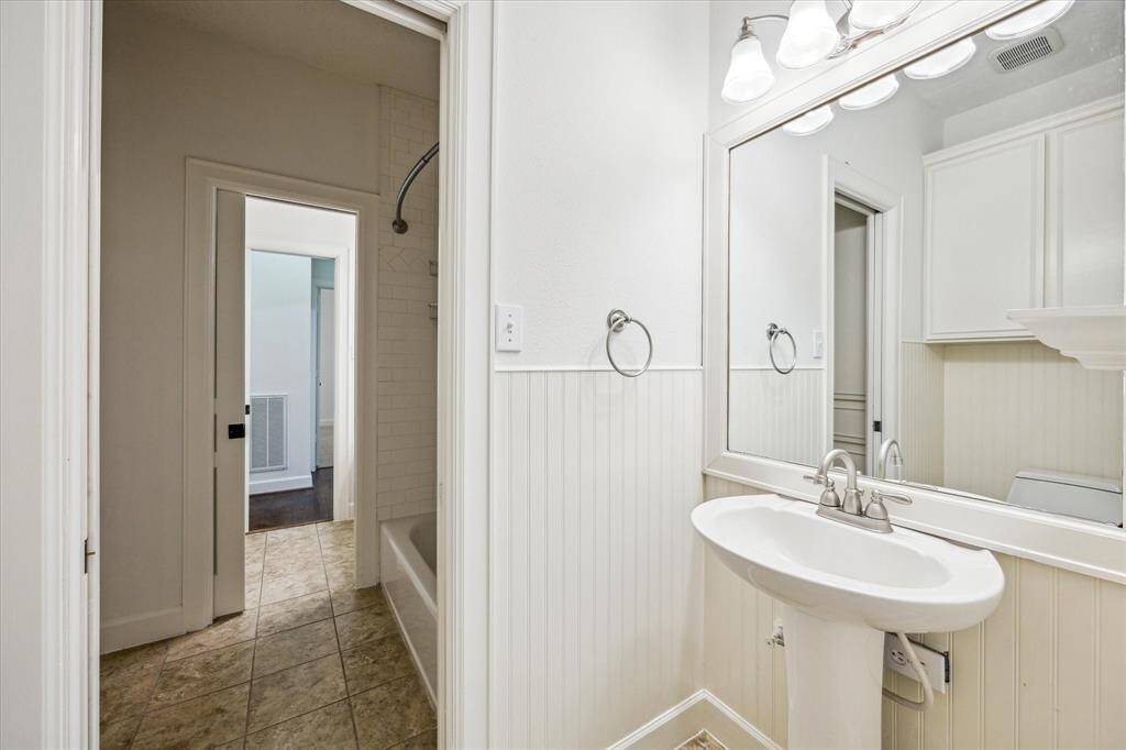 Jack & Jill bath with toilet and sink on each side of the tub and shower (in the middle).