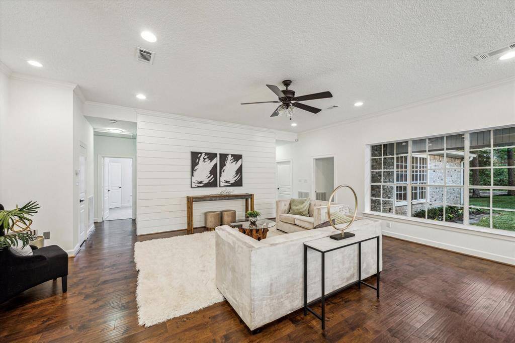 Open living room with windows facing the back covered patio.