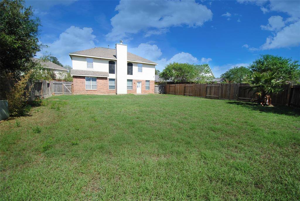 Spacious two-story home with a large, fenced backyard, perfect for outdoor activities. The house features a combination of brick and siding, with ample windows for natural light. Ideal for families seeking room to grow.