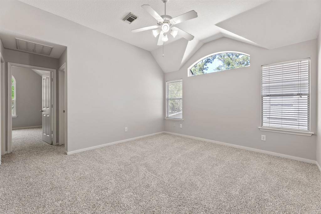 It has abundant natural light from two large windows and an arched transom, with an adjacent entryway to another room.