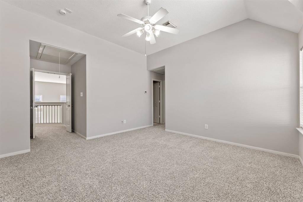 It connects to a hallway with double doors and features vaulted ceilings for an open feel.