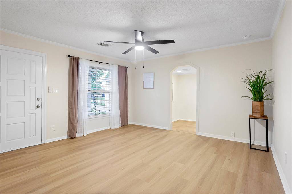 Living room has new LVP floors, window treatments, fan light