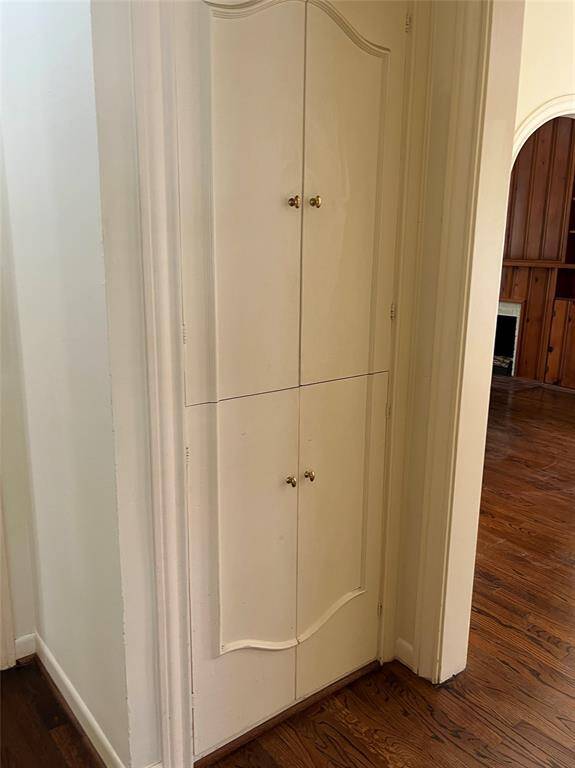 In the hallway, the linen closet has doors with charming trim.