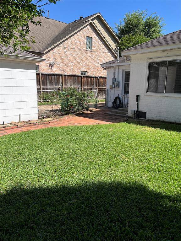 The backyard is so lovely and a great place to entertain.  A brick walkway begins at the back door and  goes to the pedestrian dor of the garage.