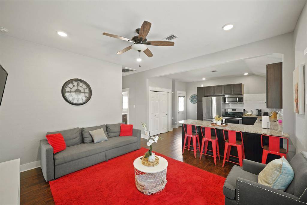 Charming two-story triplex with a fenced front patio, nestled in a quiet neighborhood. Features a spacious driveway and surrounded by greenery, offering a cozy and inviting atmosphere.