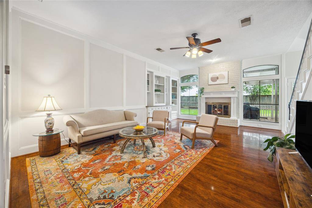 You can’t miss the beautiful craftsmanship of this room - elegant floors, custom built-ins, fresh paint - anchored by a cozy brick fireplace perfect for gatherings.