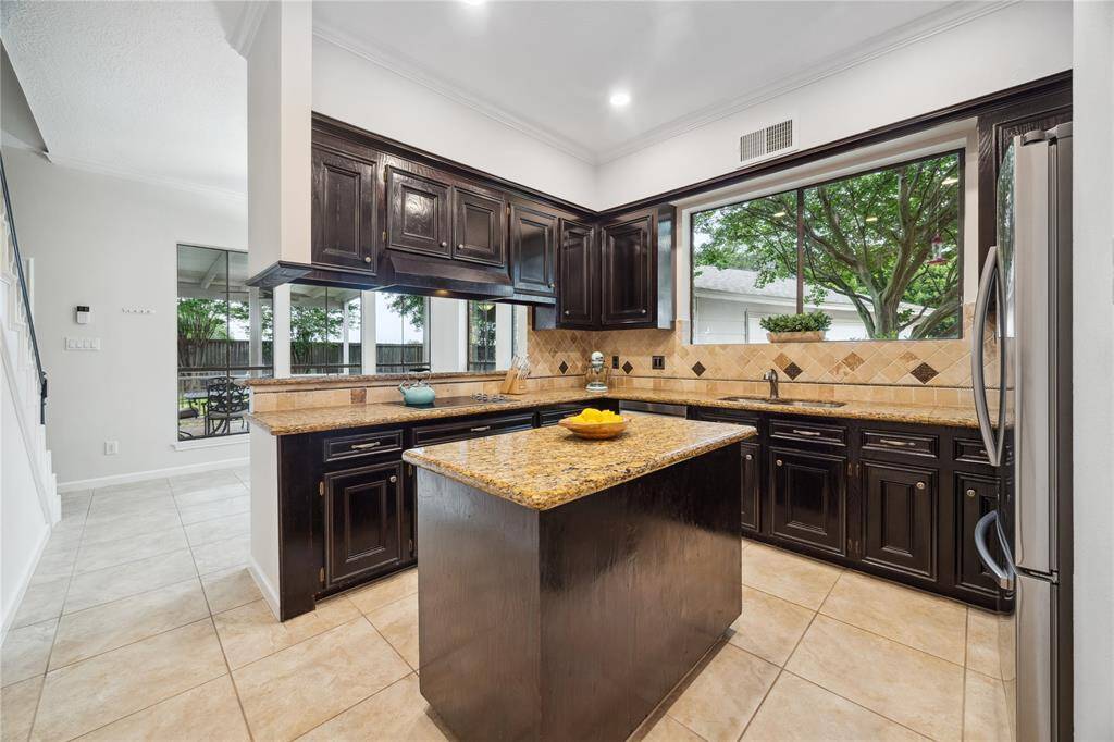 The kitchen features granite counters, stained cabinets, new recessed lighting and a central island perfect for Sunday meal-prep.