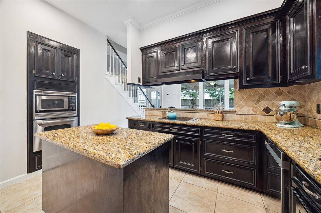 The kitchen features granite counters, stained cabinets, new recessed lighting and a central island perfect for Sunday meal-prep.