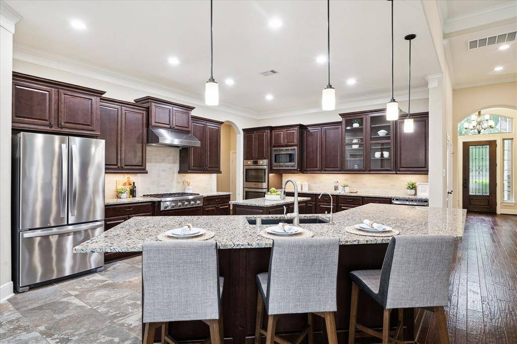 Truly spacious kitchen with a 6 burner Thermadore gas cooktop, double oven, large island with breakfast bar seating, numerous 42" cabinets with undercabinet lighting.  Truly a chef's delight.