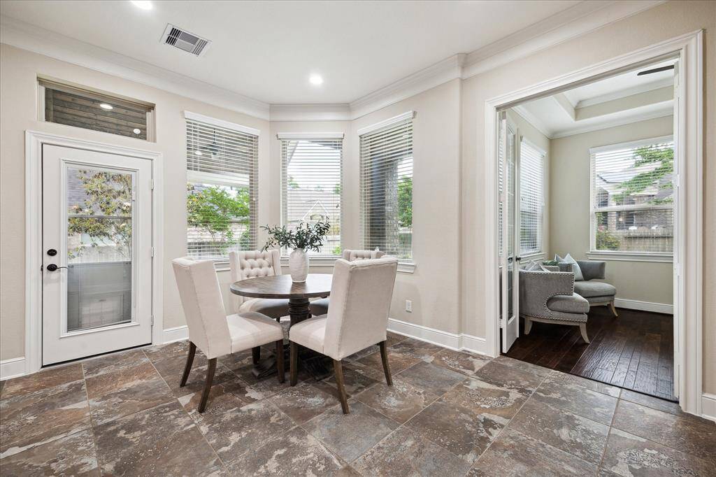 Breakfast area surrounded by windows overlooking the landscaped back yard.  Office located through the double doors.