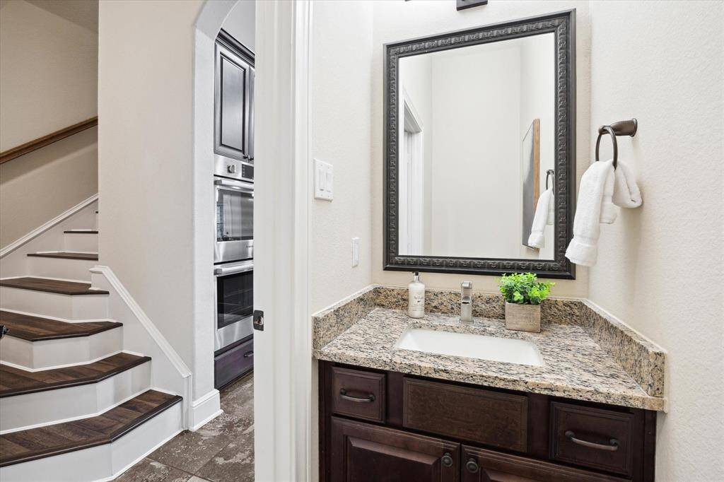 Guest bath located just off the kitchen.  Stairs to the left lead to the game room and 2 bedrooms upstairs.