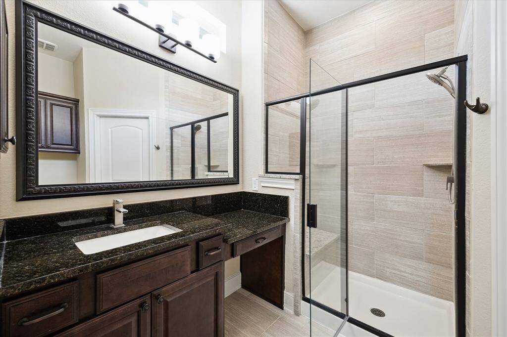 En-suite bath for front bedroom.  Notice large shower with seating area and handsome marble counters.