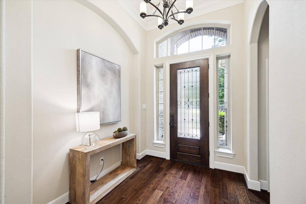 Large inviting entry with aboundant natural light. The neutral colors are contrasted nicely with the beautiful hardwood floors. Large front bedroom down the hallway to the right.