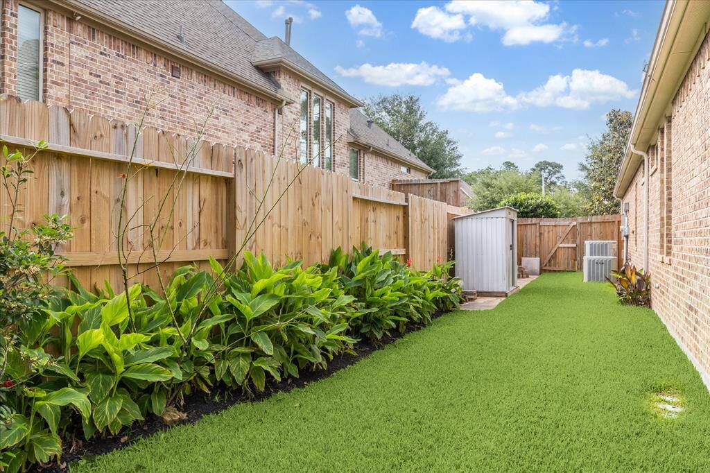 Landscaped side yard with storage shed in the background.