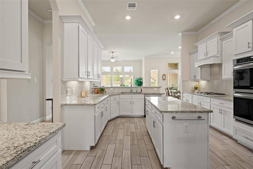 This inviting, sunlit kitchen serves as the vibrant centerpiece of the home.
