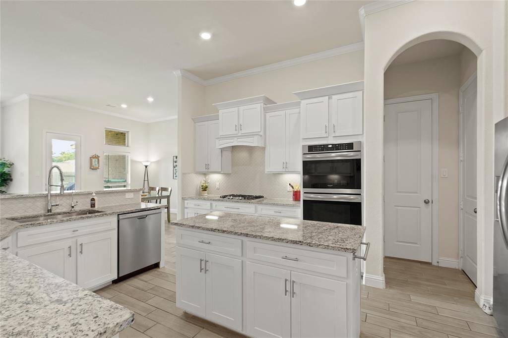 Discover the kitchen's convenience: a large, walk-in pantry next to the double ovens and easy garage access beside the fridge.