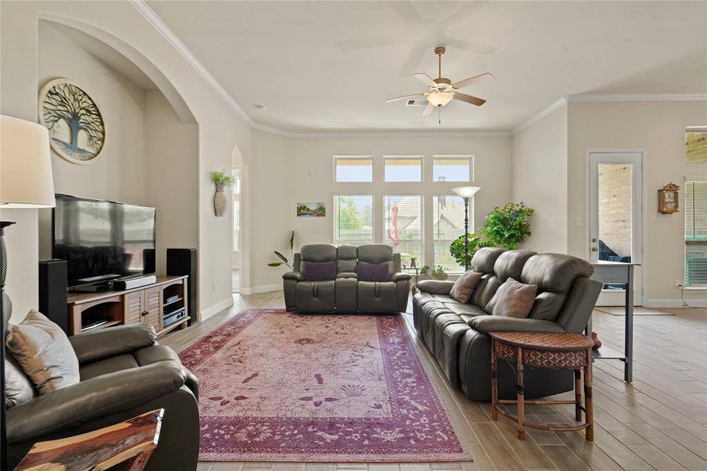 Enjoy abundant natural light in the living room, with large windows overlooking the covered back patio.