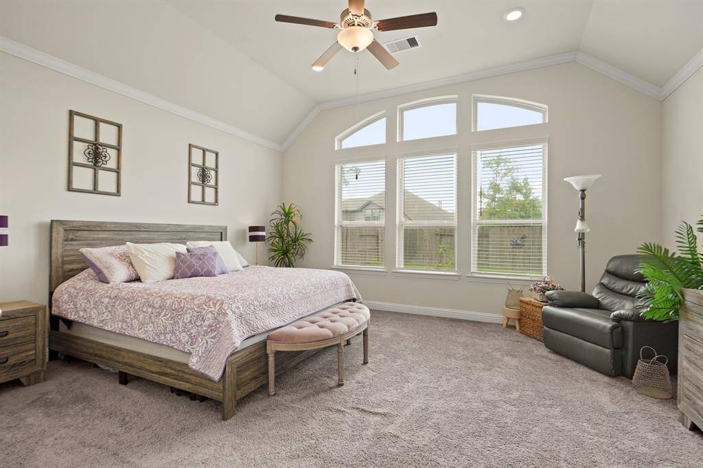 The primary suite boasts vaulted ceilings and a spacious sitting area flooded with natural light through large windows.