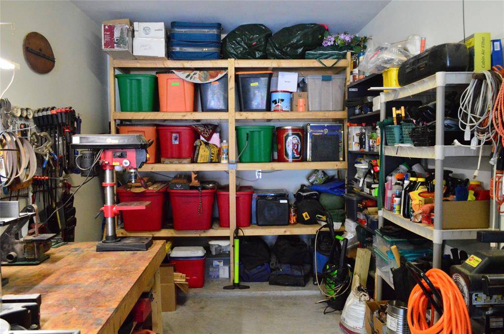 The garage features sturdy wooden shelves, ideal for creating your own workshop space.