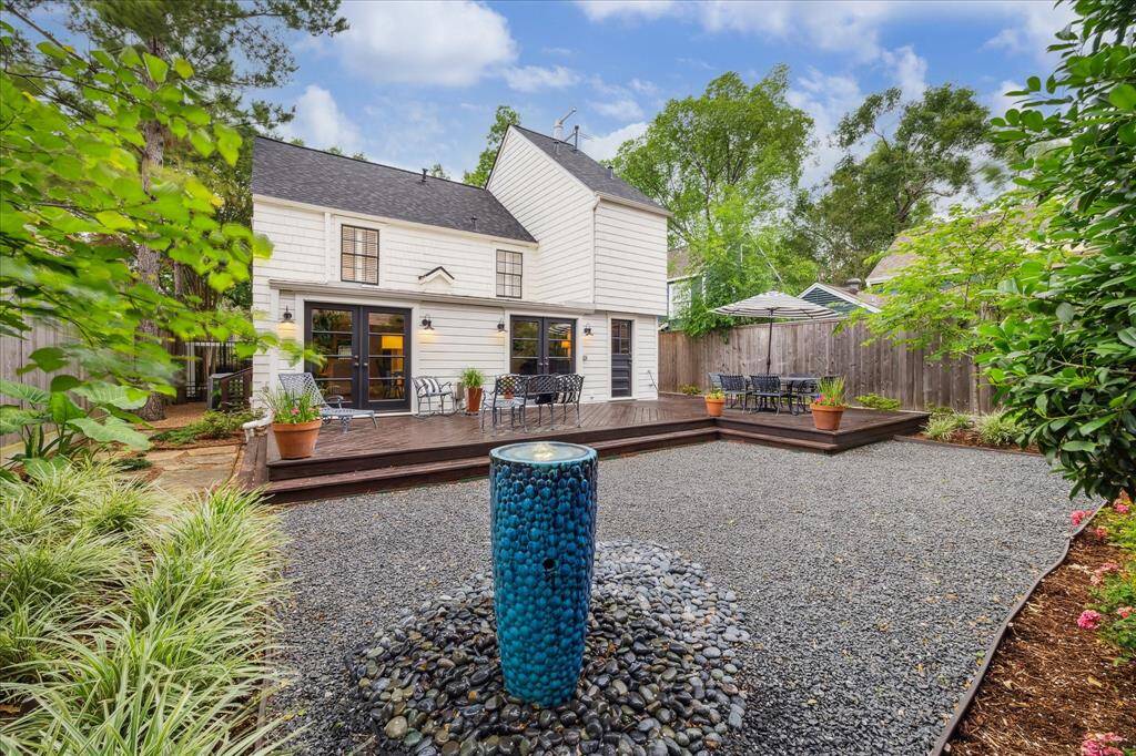 Beautiful view of the back of the house. This professionally landscaped and low maintenance yard is picture perfect! The fountain will remain with the home.