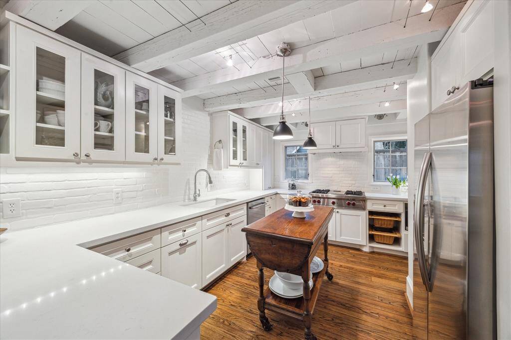 Lots of working counter space and cabinetry make this kitchen work. Notice the double sink, Wolk gas range and the built-in storage baskets. Beautiful!