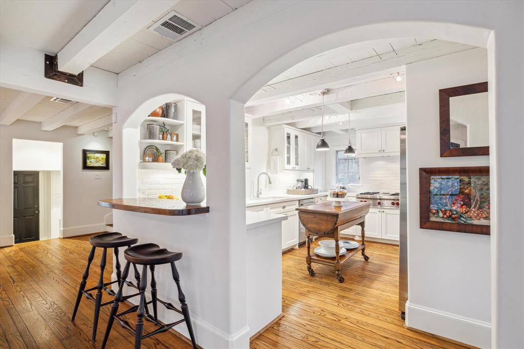 Lovely arched openings and view of steps to garage door and access to mud room and utility room.