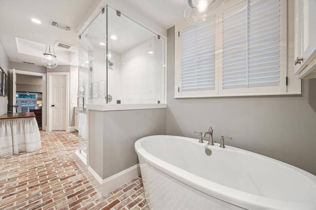 View towards the bedroom shows off the water closet, vanity table and the stand alone soaking tub.