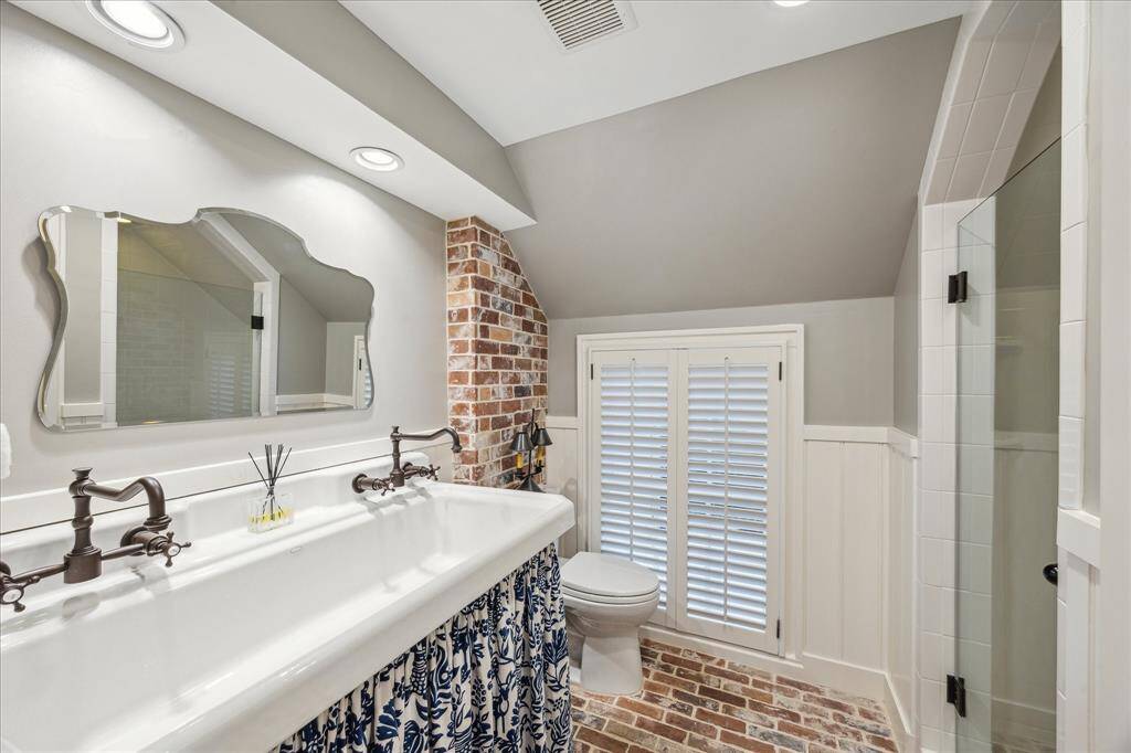 Hall Bathroom- Awesome vintage style double sink with skirting, brick flooring and brick partial wall. This bathroom serves the 2 secondary bedrooms.