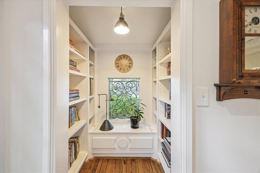 The Library nook is one of the favorite architectural features of this home. Front and center is the exquisite leaded glass window anchored by the built-in window seat and shelving.