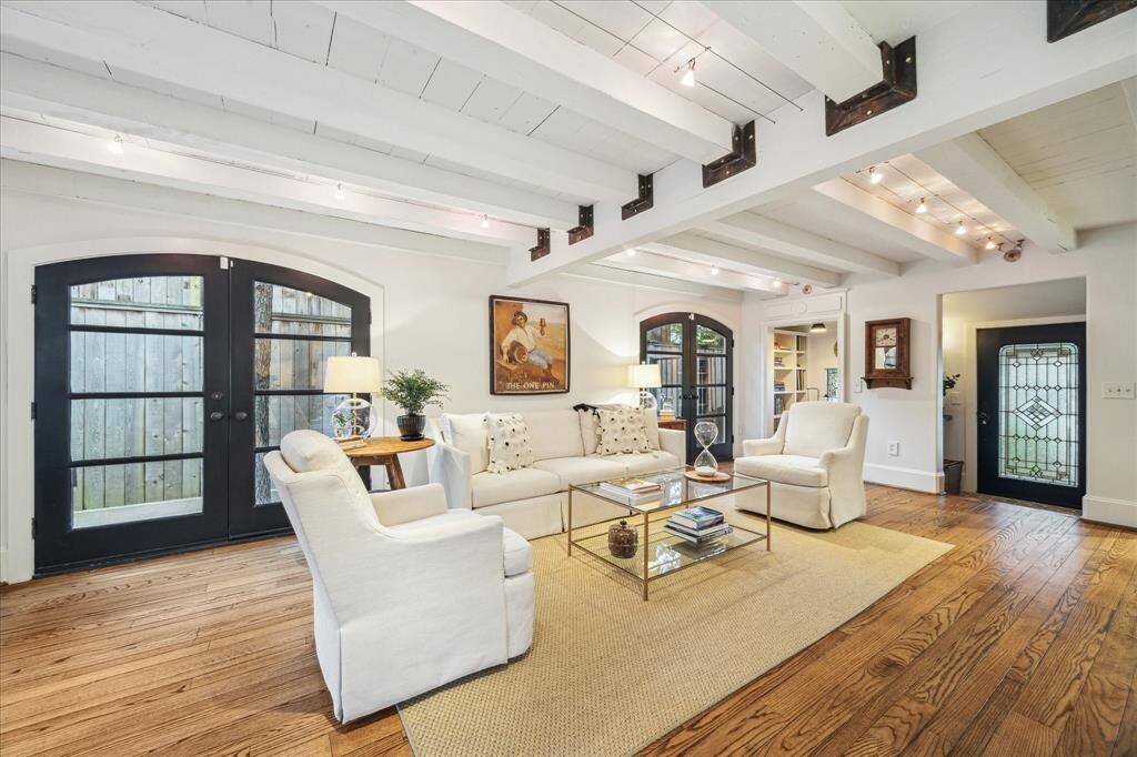 Living Room- Open concept living with beamed ceiling, shiplap paneling and multiple French doors bringing the outside in.