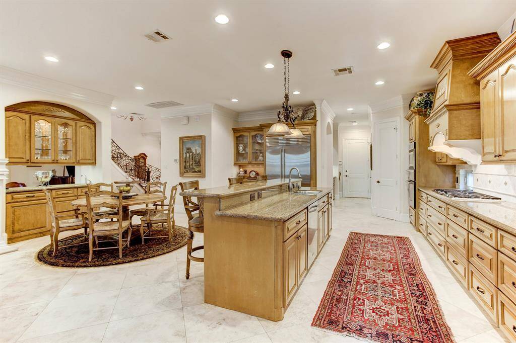 Another view of kitchen and breakfast area.  Note the additional glass cabinets and storage next to the Subzero refrigerator and the butlers pantry beyond.  There is also a pantry to the right of the stainless ovens.