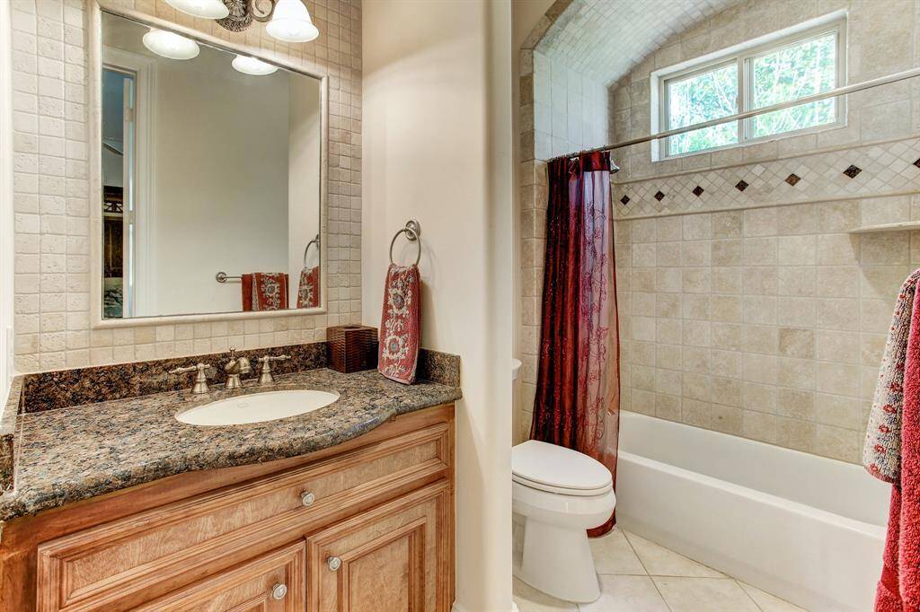 Secondary ensuite bath with tub and shower head.